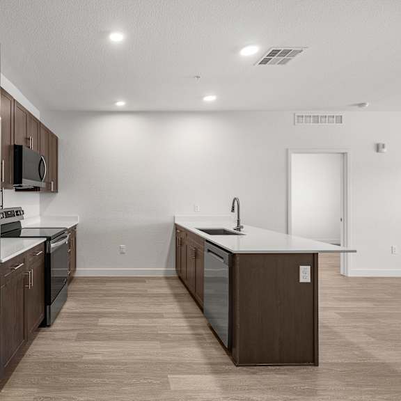 a modern kitchen with a stainless steel refrigerator and wooden cabinets.