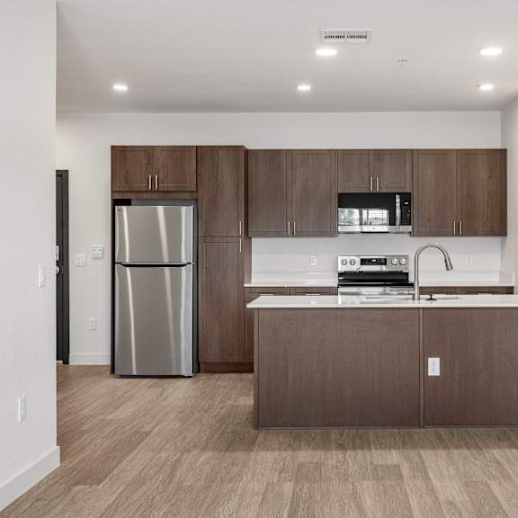 kitchen with brown cabinets, stainless steel appliances and white counters.