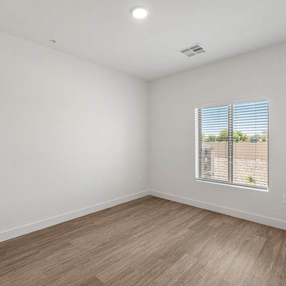 a room with a window and wooden flooring.