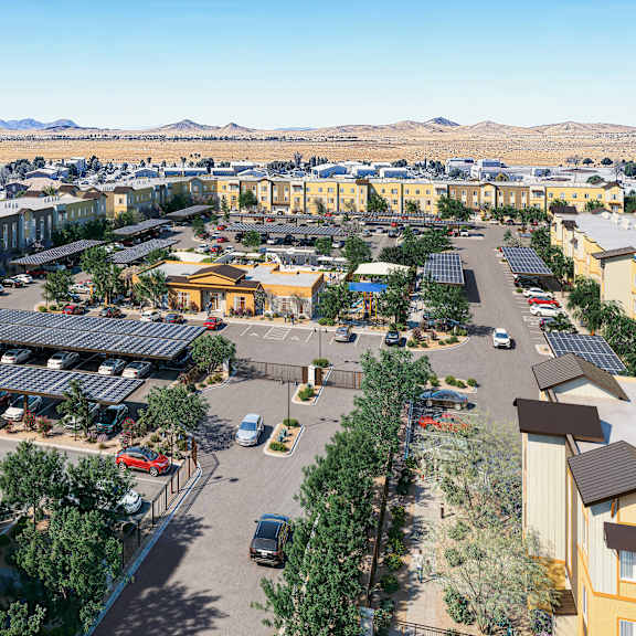 a large apartment complex with a parking lot in the foreground.