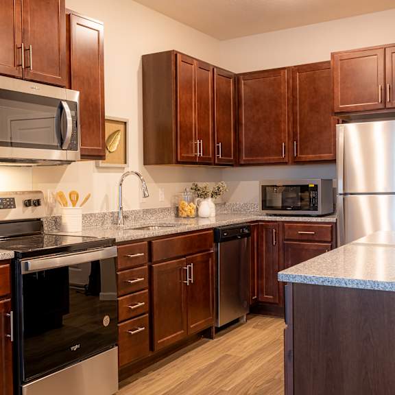 a kitchen with wood cabinets and stainless steel appliances and a counter top