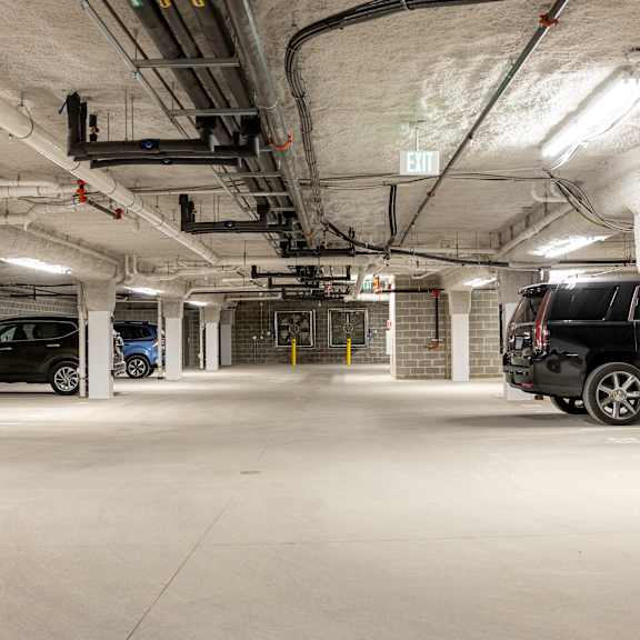 the underground parking garage of a building with parked cars