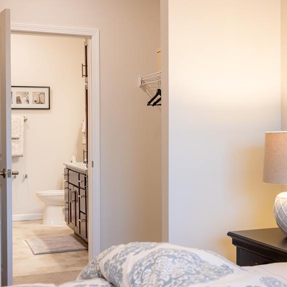 a bedroom with a bed and a lamp and a bathroom