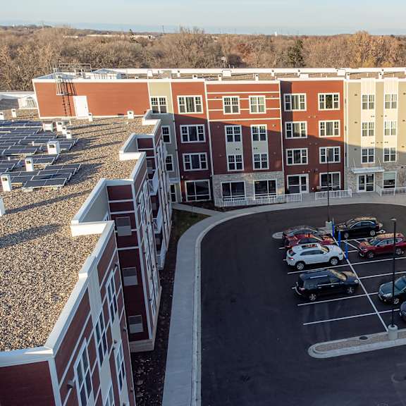 an aerial view of a parking lot in front of an apartment building