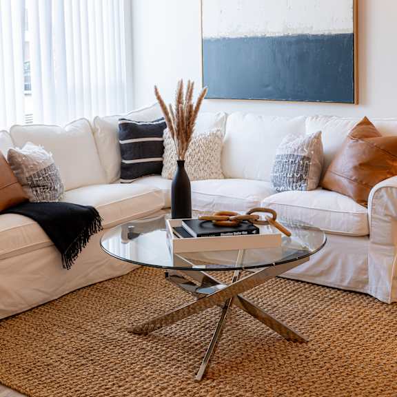 a living room with a white couch and a glass coffee table