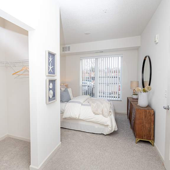 a bedroom with a bed and a closet and a window