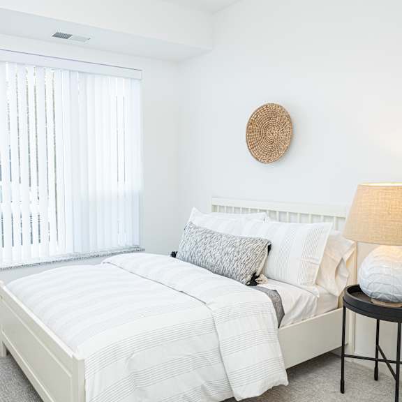 a bedroom with a bed and a large window