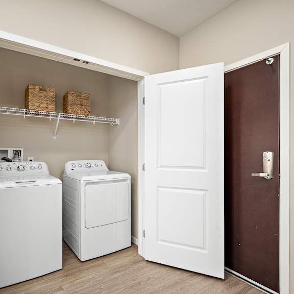 a laundry room with a washer and dryer in it at the winslow 62+ apartments, west st paul, mn