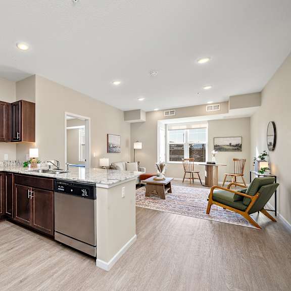 a kitchen with brown cabinets and stainless steel appliances at the winslow 62+ apartments, minnesota, 55118