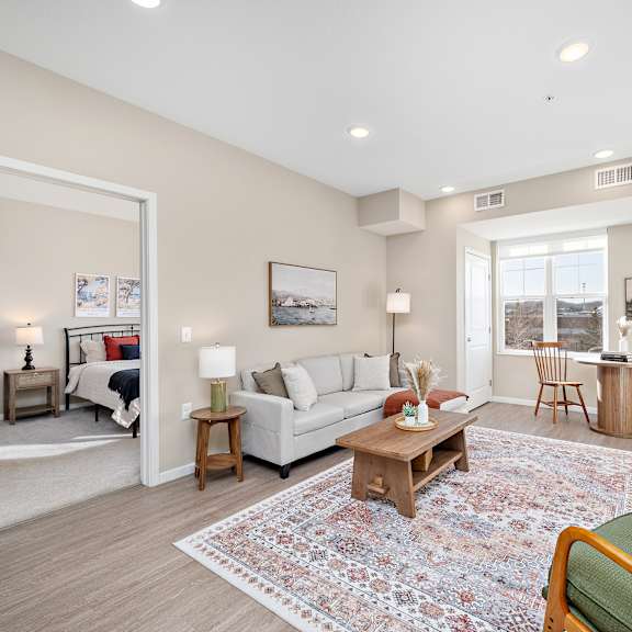 a living room with a white couch, a coffee table, and a rug at the winslow 62+ apartments, west st paul, mn