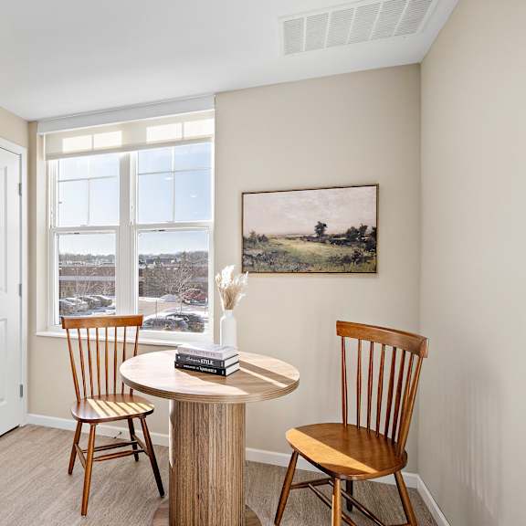 a room with a table and chairs and a painting on the wall at the winslow 62+ apartments, west st paul, mn, 55118