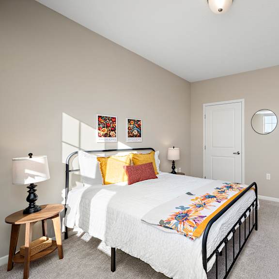 a bedroom with a bed, a nightstand, and a mirror at the winslow 62+ apartments, west st paul, 55118