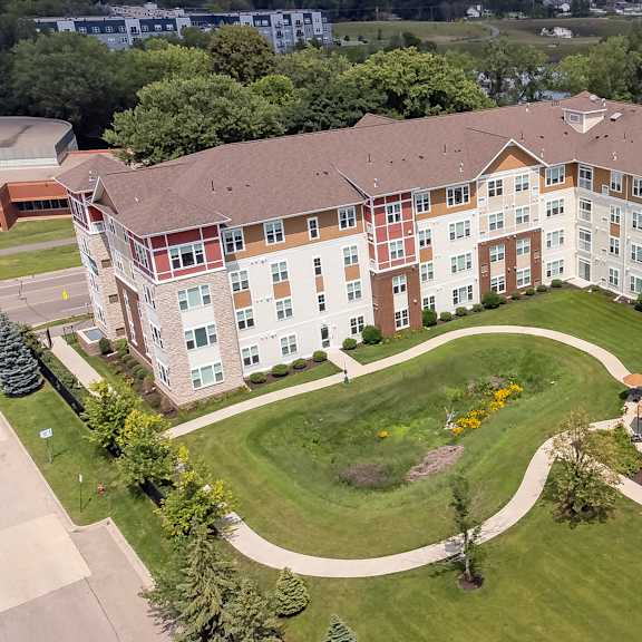 an aerial view of an apartment building with a green lawn and sidewalk at the winslow 62+ apartments, minnesota