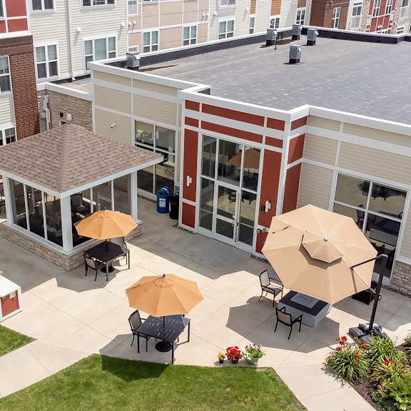 an aerial view of the courtyard of a building with tables and umbrellas at the winslow 62+ apartments, west st paul, mn, 55118