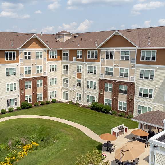 an aerial view of an apartment building on a green lawn at the winslow 62+ apartments, west st paul