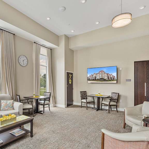 a living room with a couch and a table with chairs at the winslow 62+ apartments, west st paul, 55118