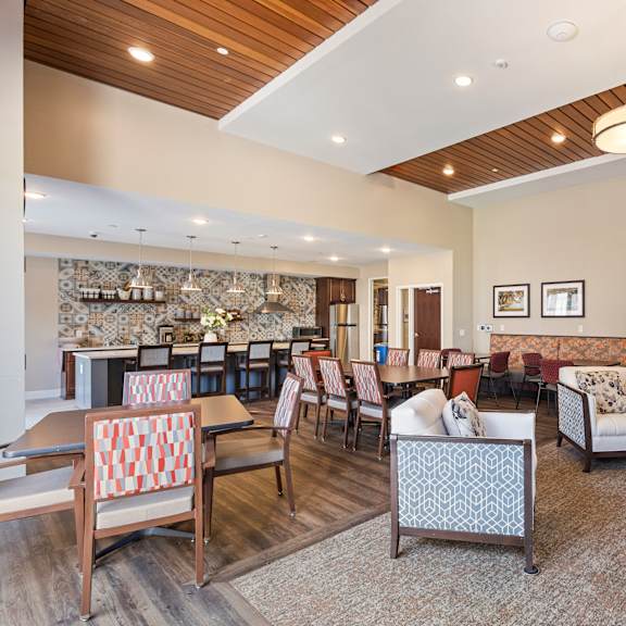 a living room with couches and chairs and a dining room with tables and chairs at the winslow 62+ apartments, minnesota, 55118