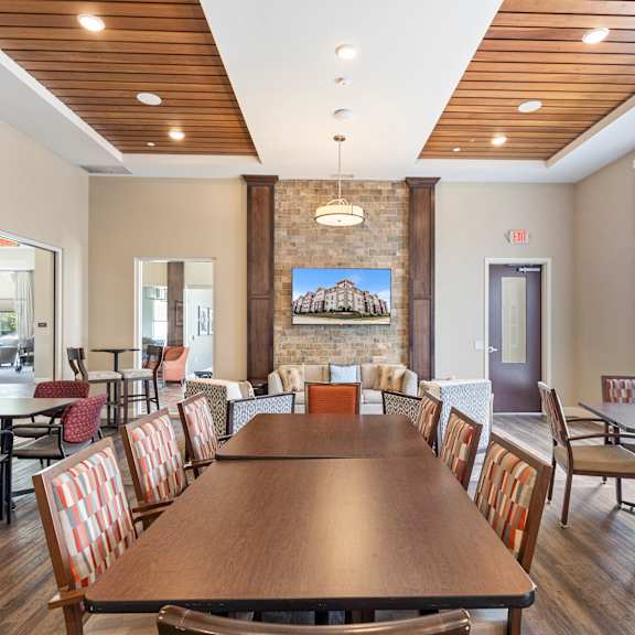a dining room with a table and chairs and a fireplace at the winslow 62+ apartments, west st paul, mn, 55118