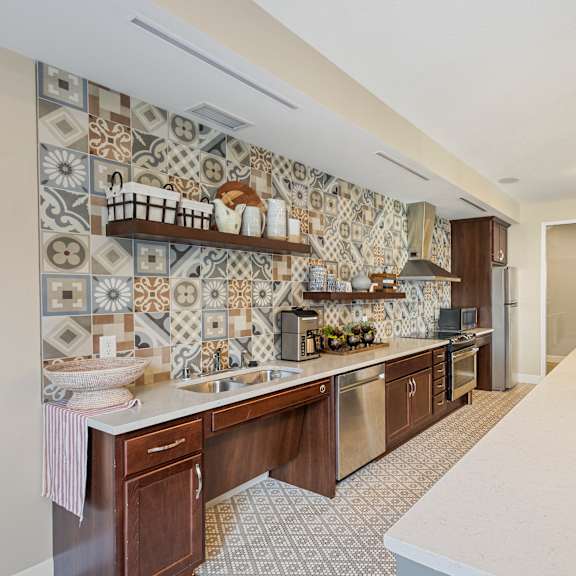 a kitchen with tiles on the wall and a white counter top at the winslow 62+ apartments, west st paul, minnesota