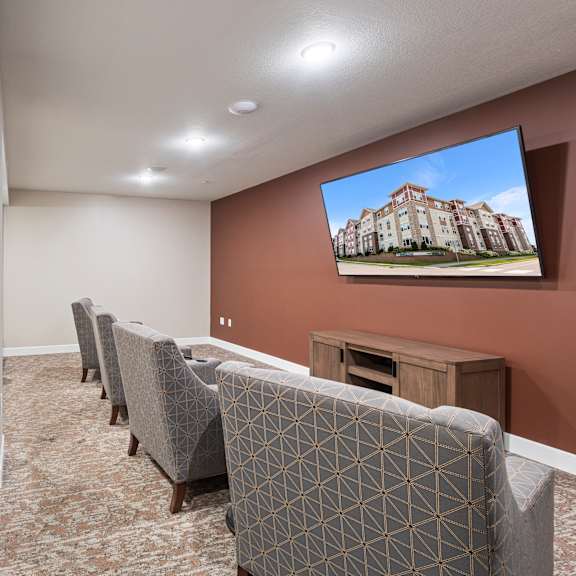 a community room with couches and chairs and a tv on the wall at the winslow 62+ apartments, minnesota