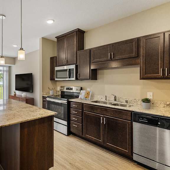 an open kitchen and living room with a table and chairs at the winslow 62+ apartments, west st paul, minnesota