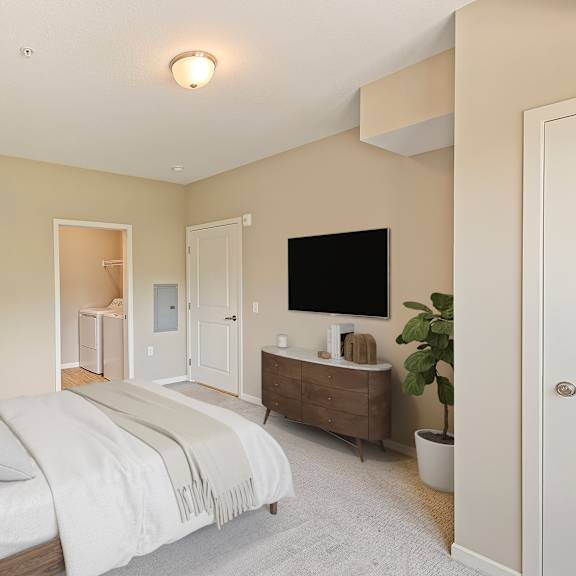 a bedroom with a bed and a dresser and a tv at the winslow 62+ apartments, west st paul, mn