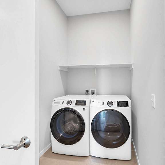 Thumbnail 11 of 13 Two washing machines in a small laundry room.