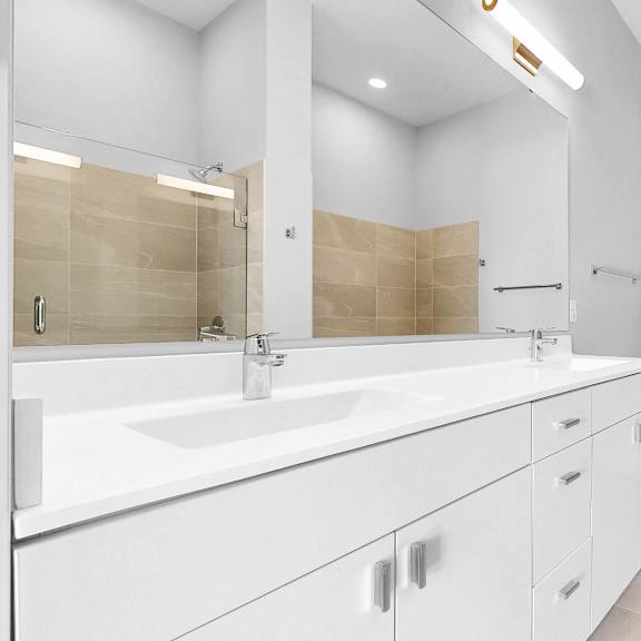 Thumbnail 10 of 12 A bathroom with a white sink and a white toilet.