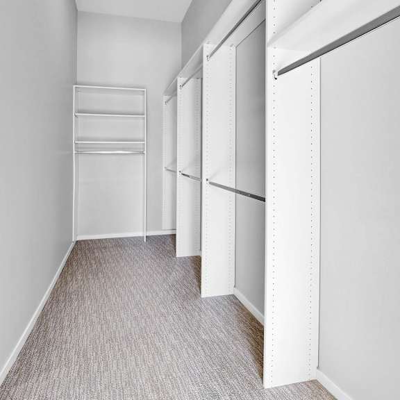 Thumbnail 11 of 12 A long hallway with white walls and a carpeted floor.