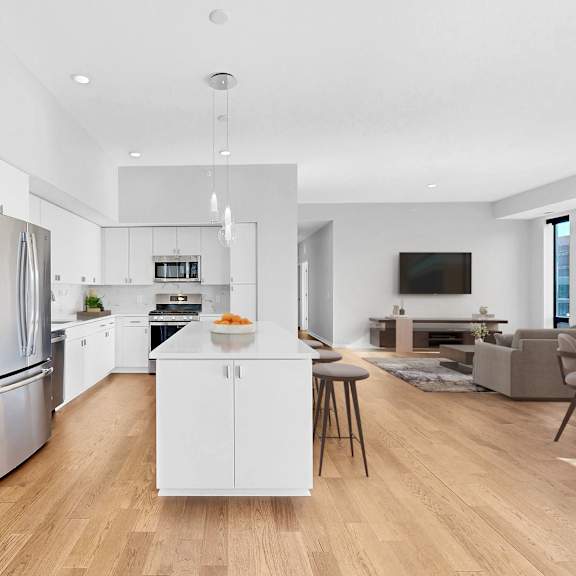 Thumbnail 3 of 12 A modern kitchen with a white island and stainless steel appliances.