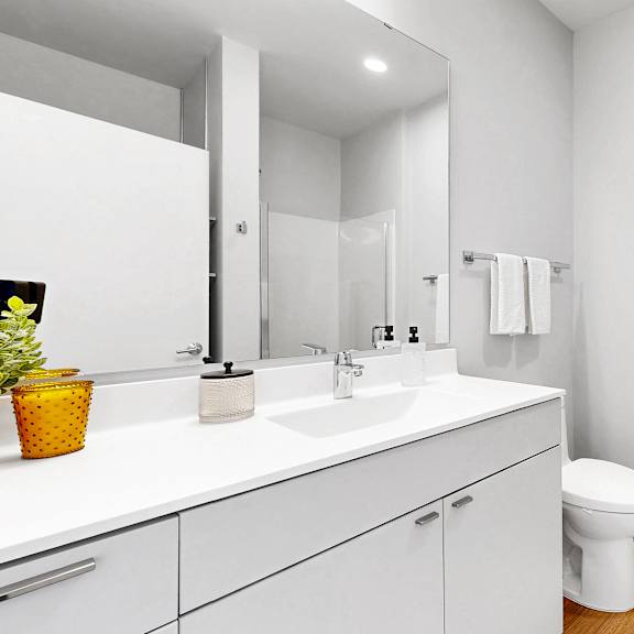 Thumbnail 10 of 10 A white bathroom with a toilet, sink, and mirror.