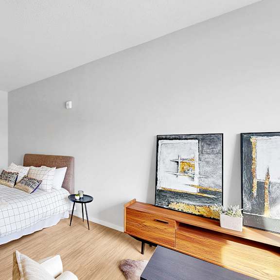 Thumbnail 8 of 10 A bedroom with a bed, a nightstand, a chair, and a painting on the wall.