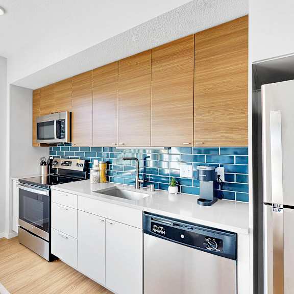 Thumbnail 4 of 10 A modern kitchen with a refrigerator on the right.