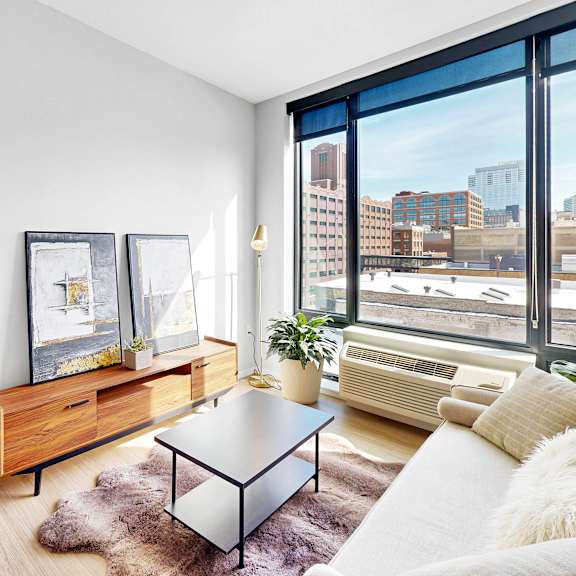 Thumbnail 7 of 10 A modern living room with a large window overlooking the city.