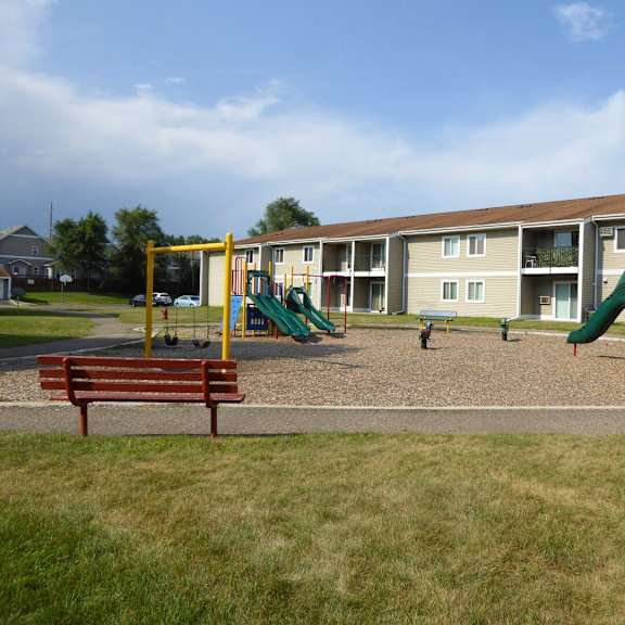 a playground with a green slide and a red and yellow structure.
