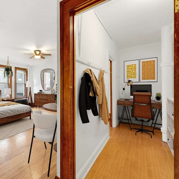 Thumbnail 2 of 3 a living room with a mirror and a bedroom with a bed