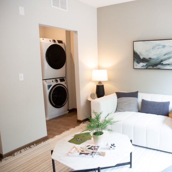 Thumbnail 2 of 3 a living room with a white couch and a washing machine
