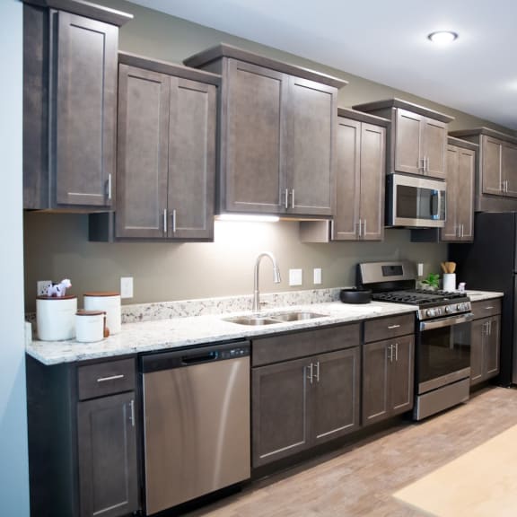 Thumbnail 3 of 3 a large kitchen with stainless steel appliances and wooden cabinets