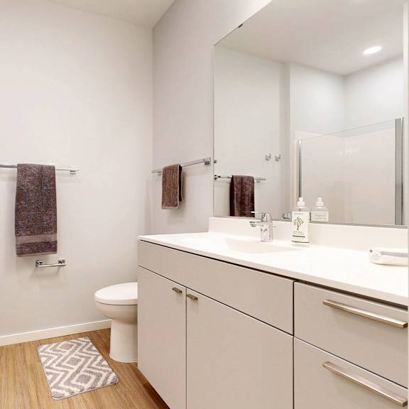 Thumbnail 5 of 8 A white bathroom with a towel hanging on the towel rack.