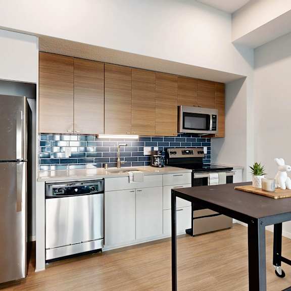 Thumbnail 8 of 8 A modern kitchen with a stainless steel refrigerator and white cabinets.