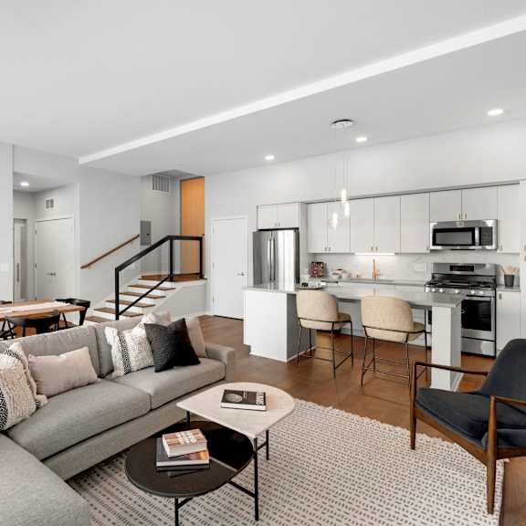 Thumbnail 3 of 7 A modern living room with a grey sofa and a coffee table.
