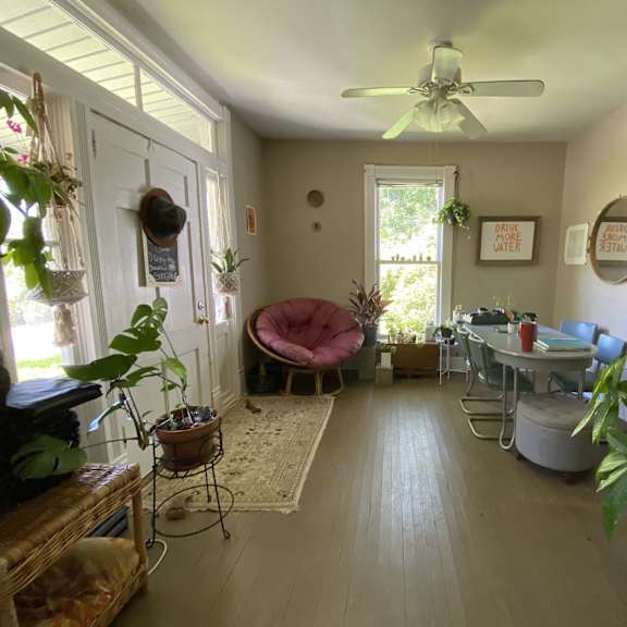 a living room with a table and chairs and a ceiling fan