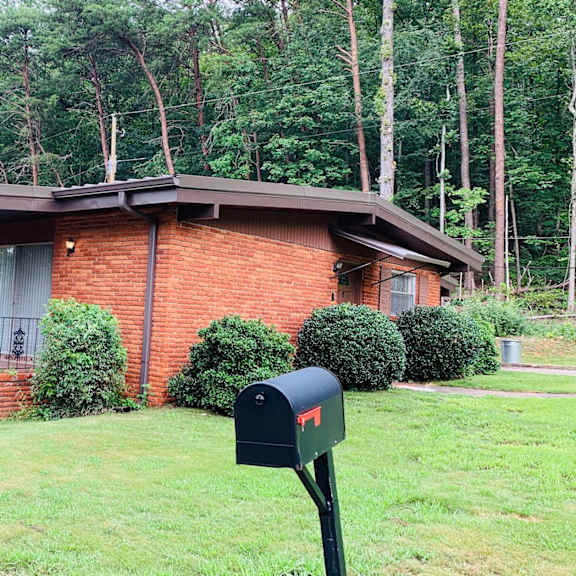 a small brick house with a mailbox in front of it