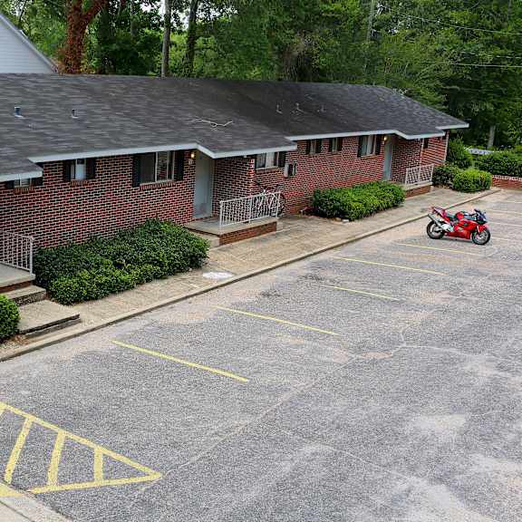 an aerial view of a brick house with a motor scooter parked in the driveway