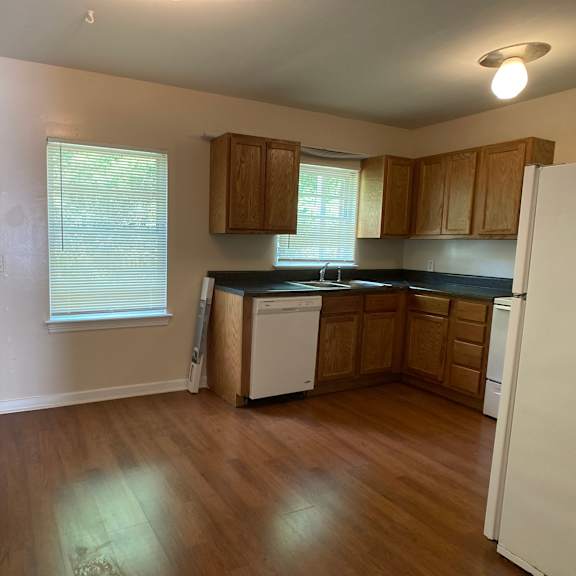 an empty kitchen with wooden floors and wooden cabinets