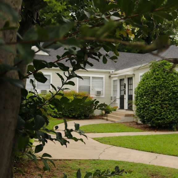 a white house with a sidewalk in front of it