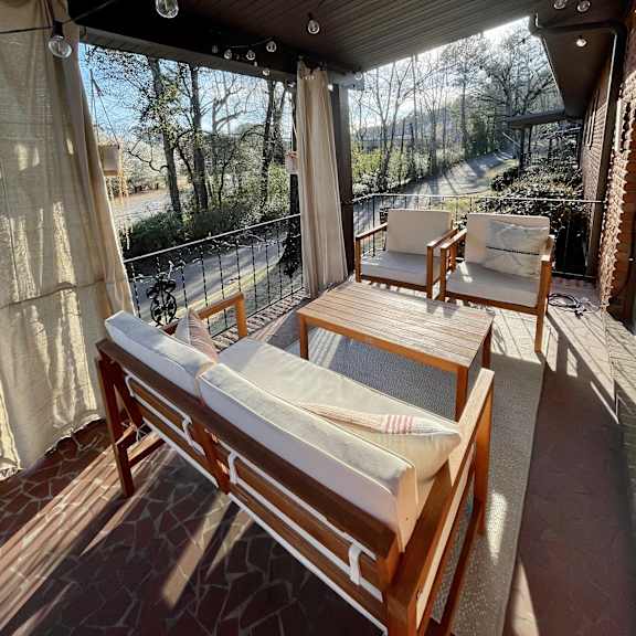 a covered porch with a table and chairs