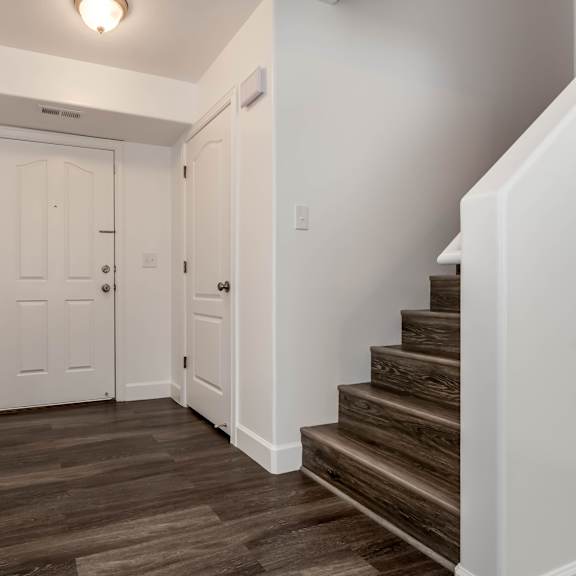 the landing of a staircase in a home with white walls and wood floors