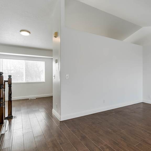 a room with wooden flooring and white walls.