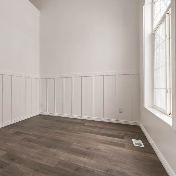 a room with wooden flooring and white walls.